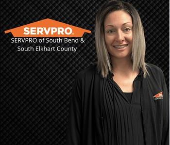 woman smiling at the camera with black background and servpro logo and franchise names
